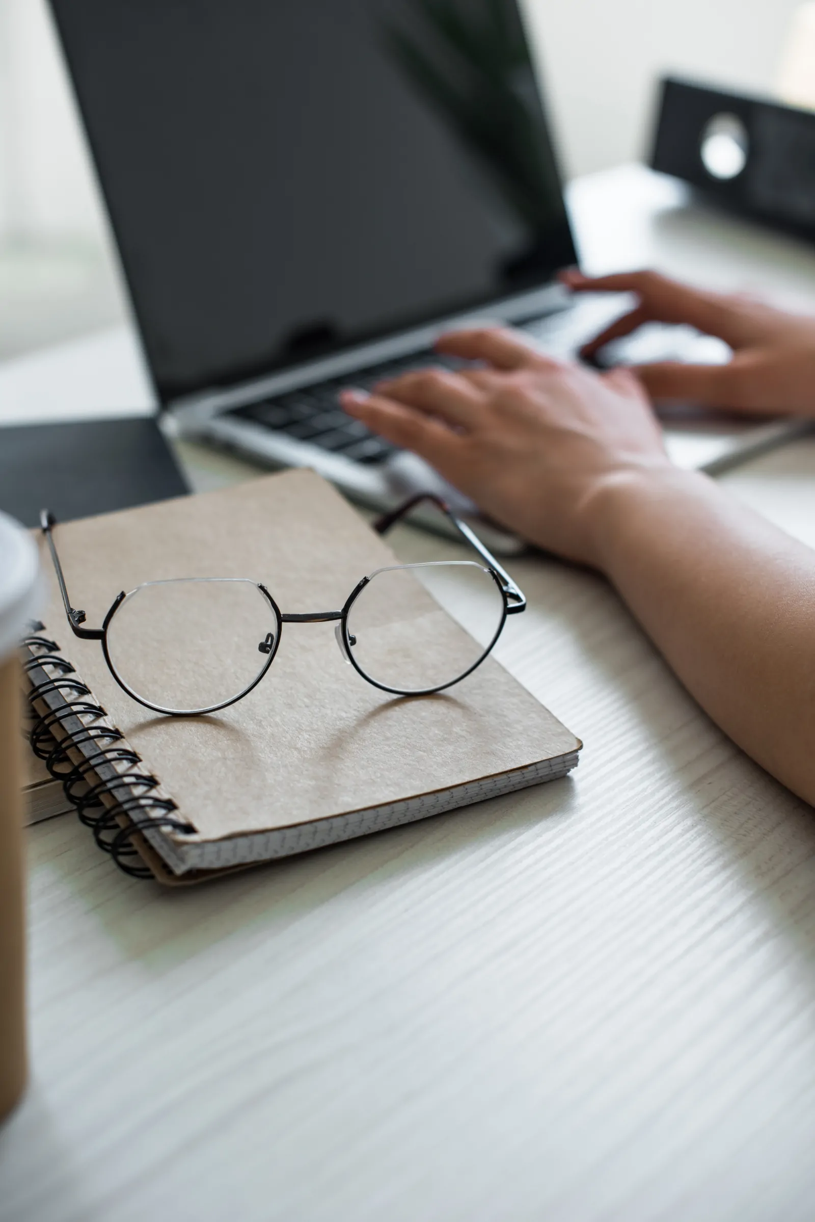 Persona trabajando con documentos y un ordenador, en un entorno de revisión y preparación de comunicaciones científicas